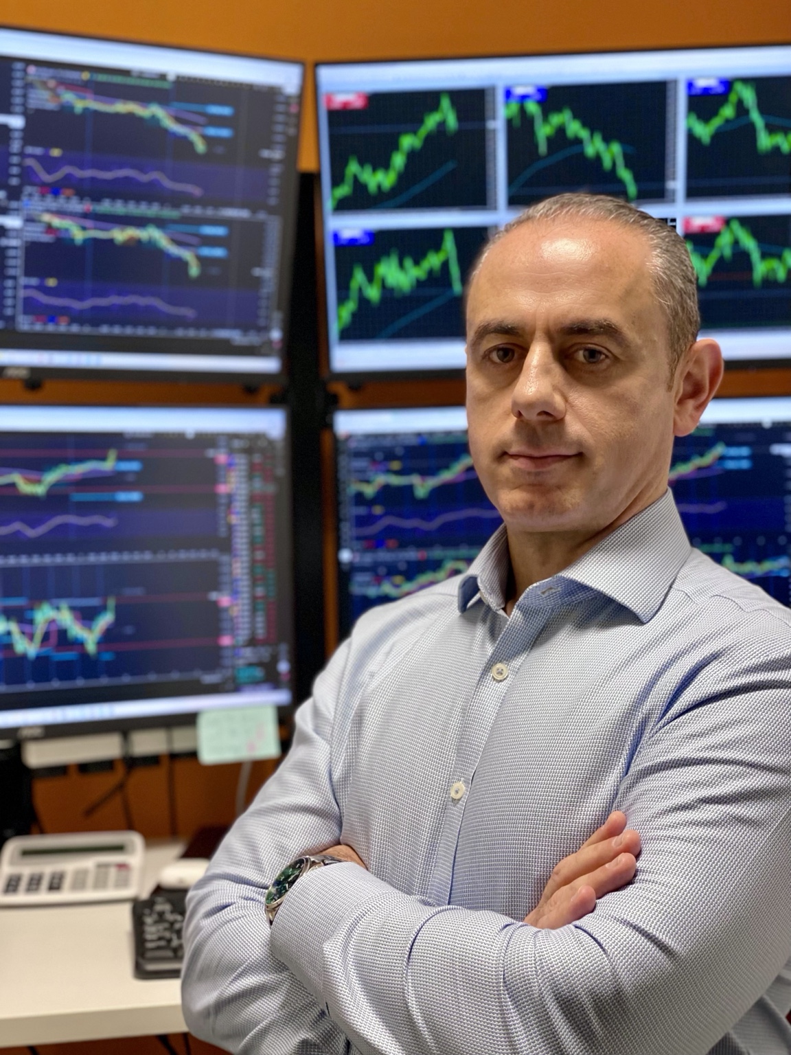 Paul Jannece in front of financial market screens